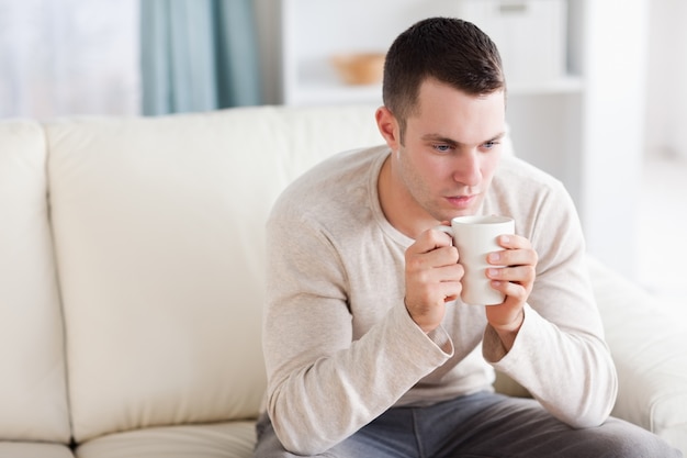 Junger Mann, der einen Kaffee trinkt