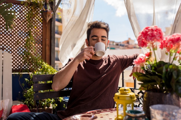 Junger Mann, der einen Kaffee trinkt