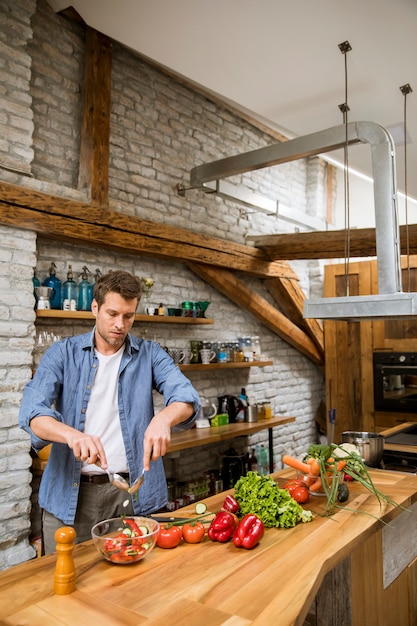 Junger Mann, der Essen in der Küche zubereitet