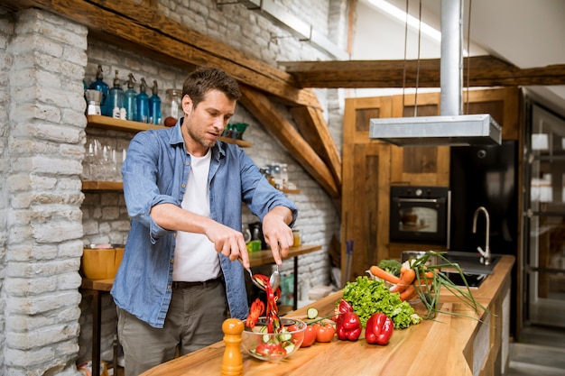 Junger Mann, der Essen in der Küche zubereitet