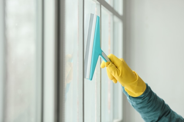 Junger Mann, der Fenster zu Hause putzt