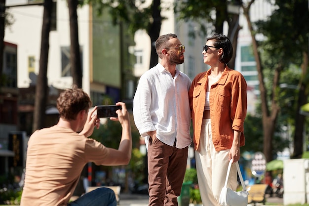 Junger Mann, der Freunde fotografiert