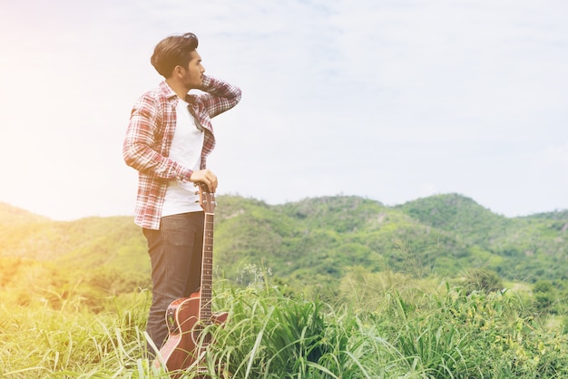 Junger Mann, der Gitarre in der Mountain View hält