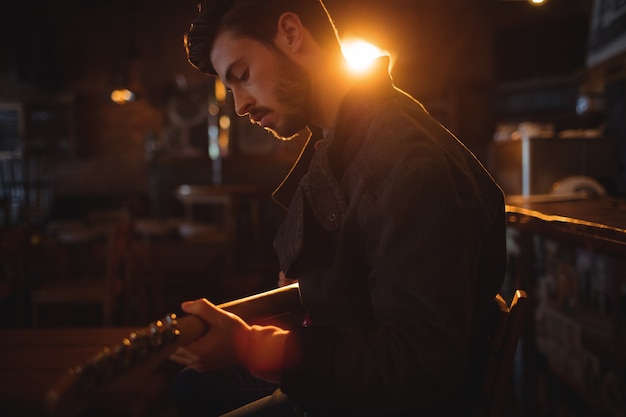 Junger Mann, der Gitarre spielt