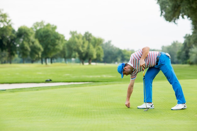 Junger Mann, der Golf spielt