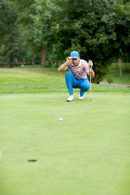 Junger Mann, der Golf spielt