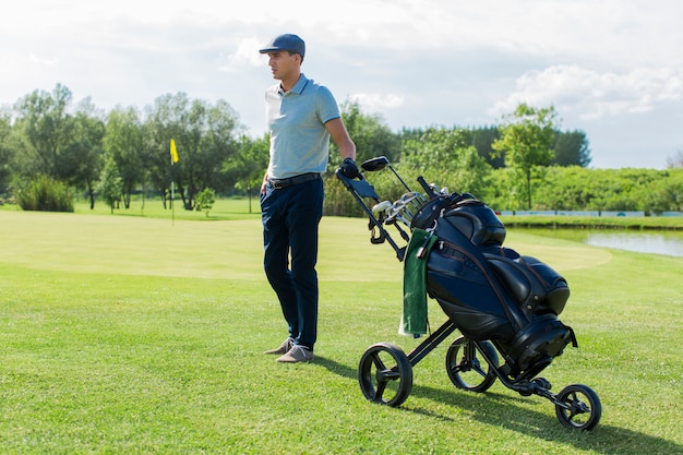 Junger Mann, der Golf spielt