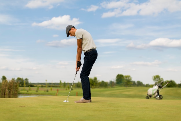 Junger Mann, der Golf spielt