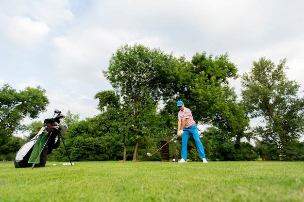 Junger Mann, der Golf spielt