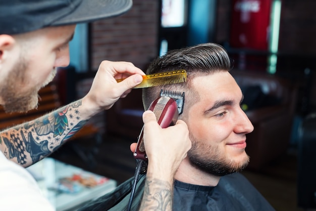 Junger Mann, der Haare schneiden lässt