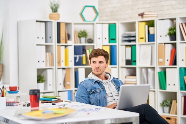 Junger Mann, der im Büro arbeitet