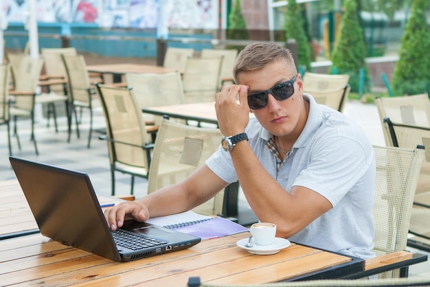 Junger Mann, der im Café sitzt