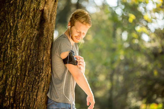 Junger Mann, der in den Herbstpark läuft