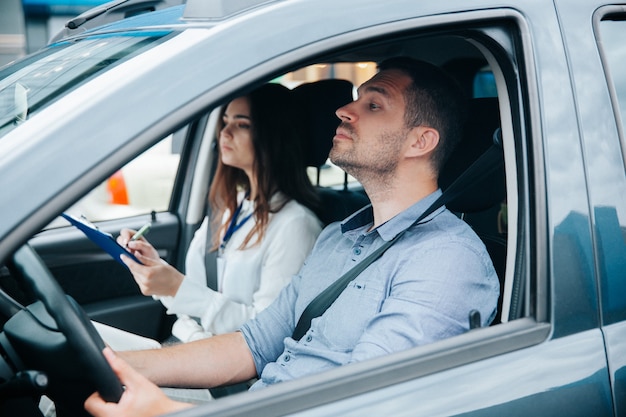 Junger Mann, der mit seinem Ausbilder ein Auto fährt