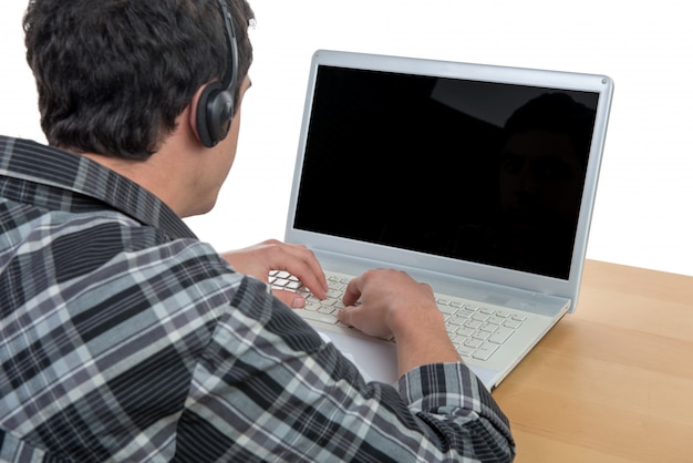 Junger Mann, der mit seinem Laptop arbeitet