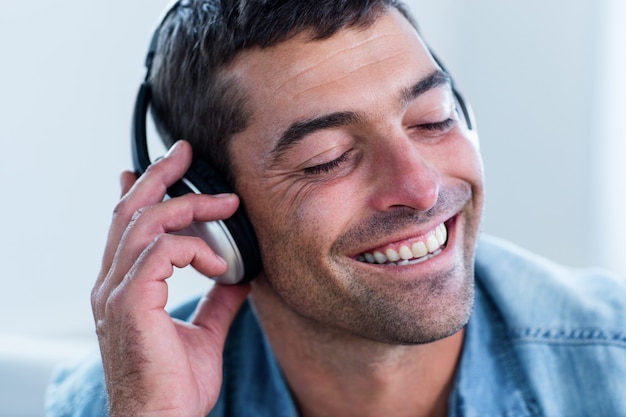 Junger Mann, der Musik am Haupttelefon hört