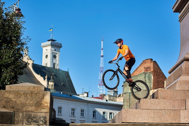 Junger Mann, der radikale Mountainbike-Sprünge in der Altstadt durchführt