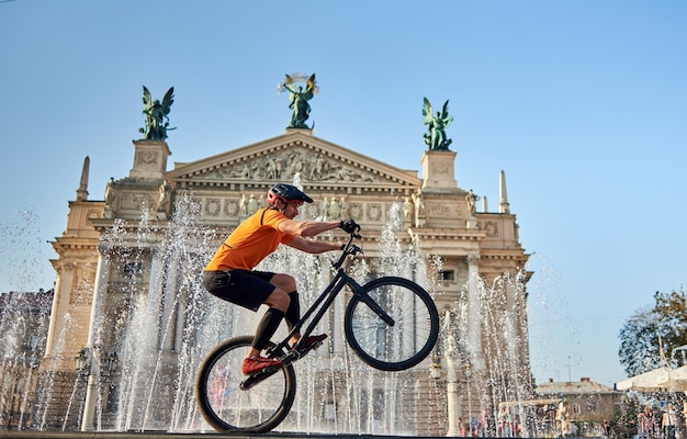 Junger Mann, der radikale Mountainbike-Sprünge in der Altstadt durchführt