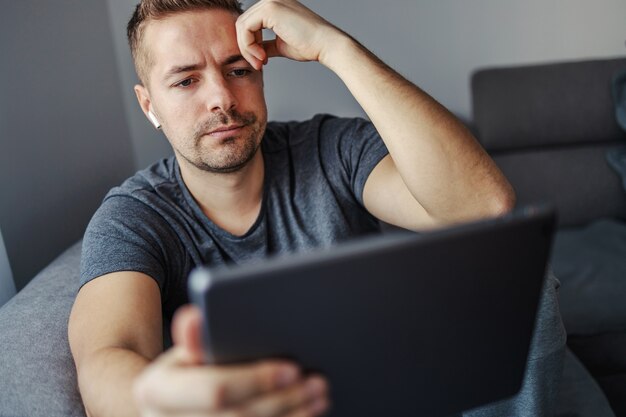 Junger Mann, der schlechte Nachrichten im Internet liest