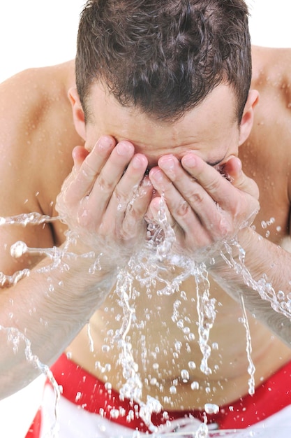 Junger Mann, der sein Gesicht mit sauberem Wasser wäscht und Hygiene- und Schönheitskonzept des Mannes repräsentiert