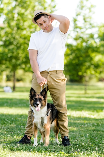 Junger Mann, der seinen Hund im Park geht