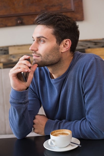 Junger Mann, der seinen Smartphone verwendet