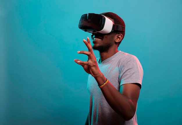 Junger Mann, der Spaß mit einem interaktiven Virtual-Reality-Headset hat und moderne Technologie mit futuristischer 3D-Vision verwendet. Millennial-Erwachsener mit Gaming-Brille mit visueller Simulation für die Freizeit.