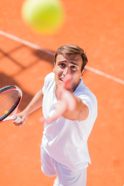 Junger Mann, der Tennis spielt