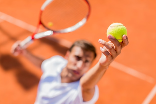 Junger Mann, der Tennis spielt