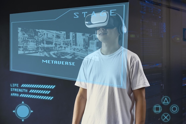 Junger Mann, der VR-Brillen mit Hologramm-Schnittstellenbildschirm verwendet und virtuelle Spiele auf Metaverse spielt