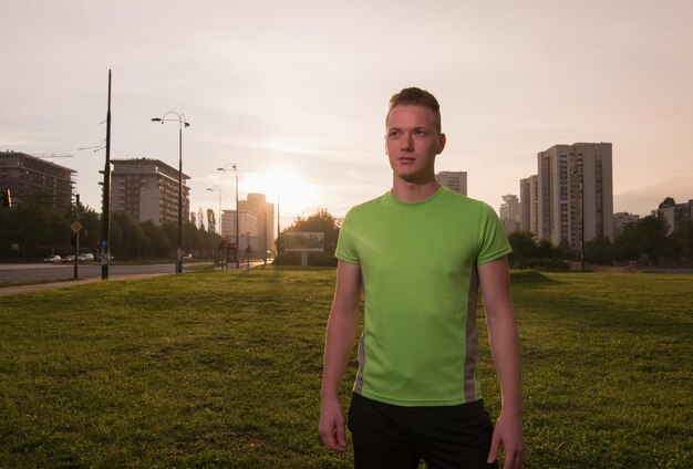 Junger Mann, der während einer Pause seines Outdoor-Jogging-Trainings auf den Rest des Weges blickt