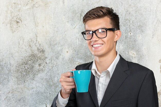 Junger Mann, der warme Tasse Tee hält