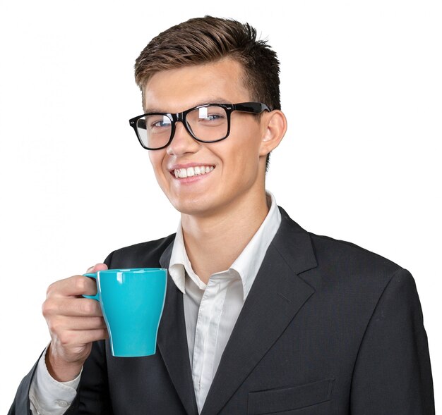 Junger Mann, der warme Tasse Tee / Kaffee hält