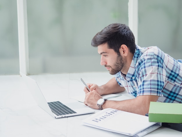 Junger Mann, der zu Hause arbeitet