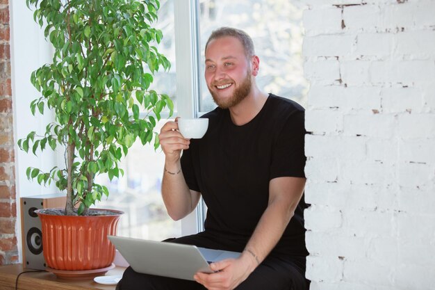 Junger Mann, der zu Hause während Online-Kursen für Analysefinanzierer studiert