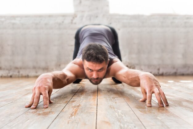 Junger Mann, der zuhause Yoga tut