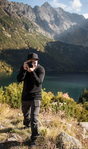 Junger Mann Fotograf Fotografieren mit Digitalkamera in Bergen