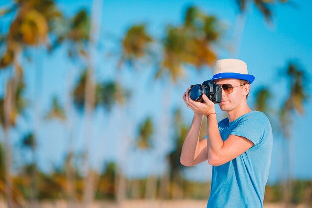 Junger Mann fotografiert am tropischen Strand