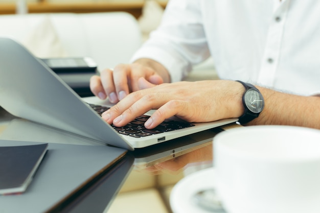 Junger Mann führt Arbeit an einem Laptop durch