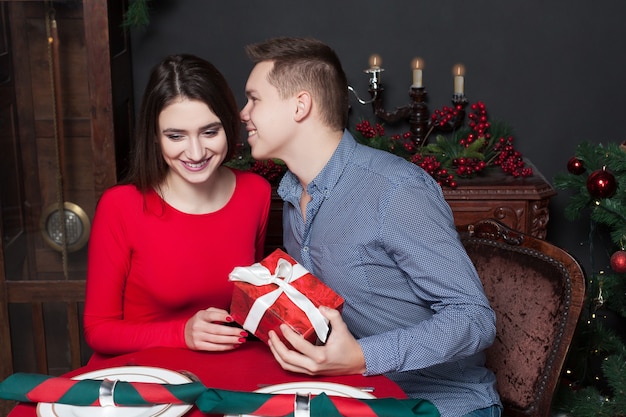 Junger Mann gibt der schönen Frau ein Geschenk