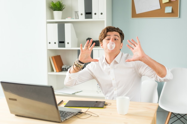 Junger Mann im Anzug, der Spaß im Büro hat