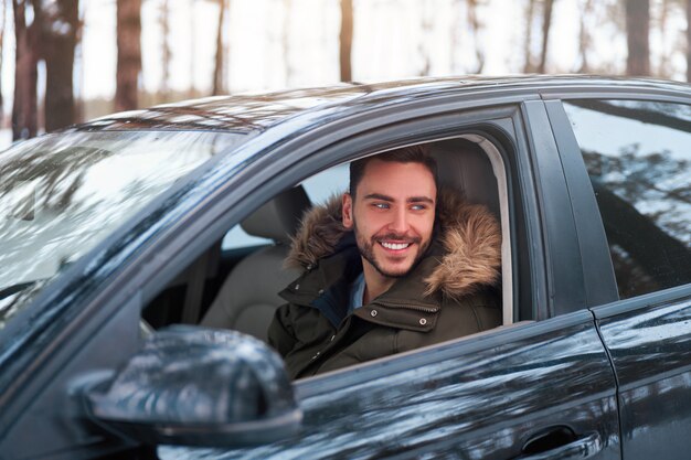 junger Mann im Auto Winterstraße