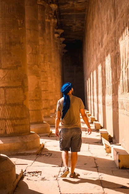 Junger Mann im blauen Turban, der den Edfu-Tempel und seine schönen Säulen nahe Assuan-Stadt besucht. Ägypten
