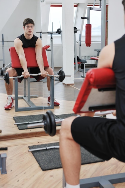 junger mann im fintess sportclub trainiert mit gewichten und entspannt sich