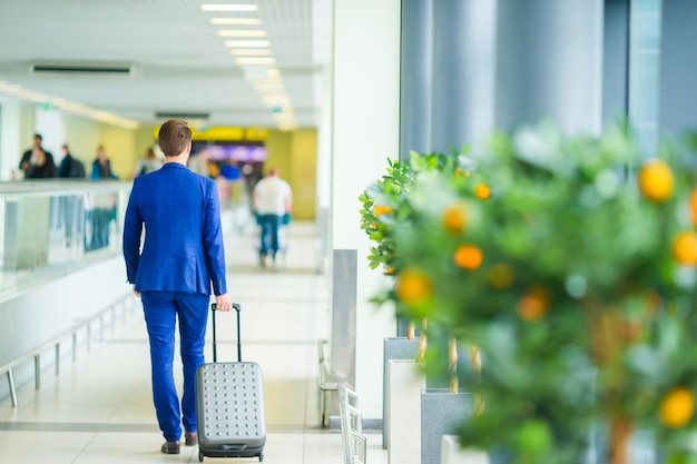 Junger Mann im Flughafen. Tragende Anzugsjacke des zufälligen Jungen.