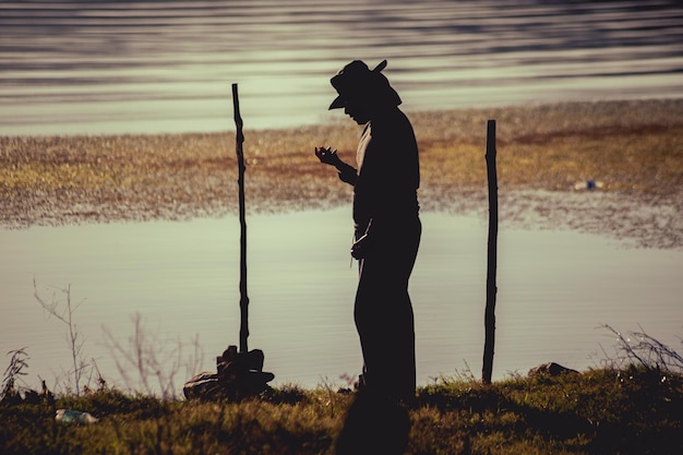 Junger Mann im Fluss mit Fischerhut