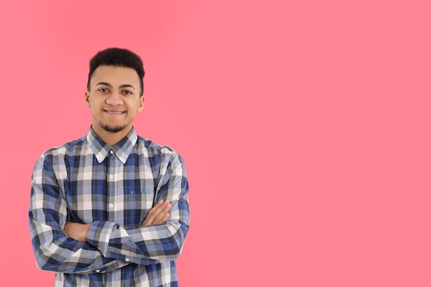 Junger Mann im karierten Hemd auf rosa Hintergrund