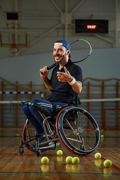 Junger Mann im Rollstuhl beim Tennisspielen auf dem Platz