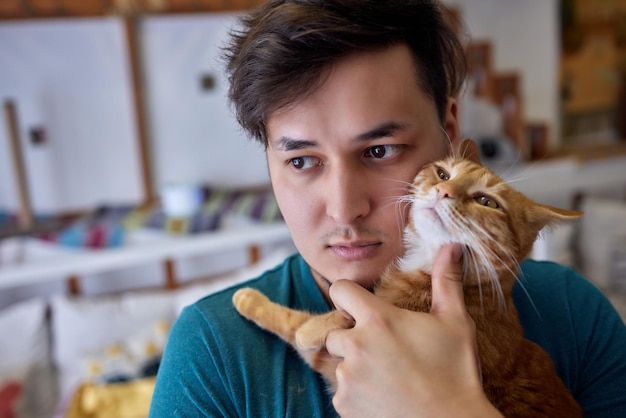 Junger Mann im T-Shirt mit einer Katze