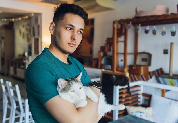 Junger Mann im T-Shirt mit einer Katze